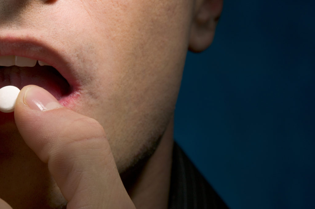 Close-up of a man taking pill over the counter pain killers and erectile dysfunction philadelphia pa